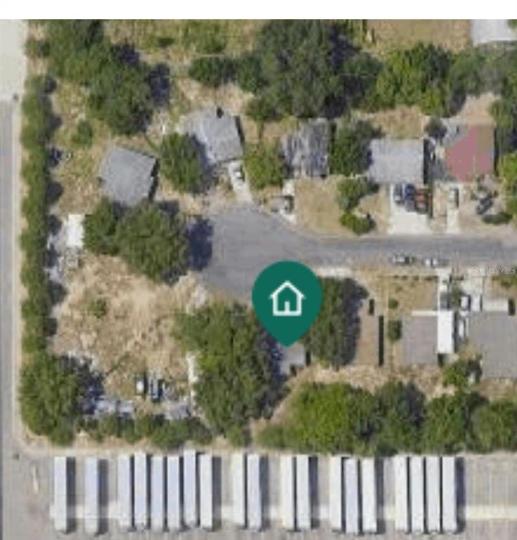 This aerial view shows a residential property lot situated next to a commercial parking area — LINCOLN COURT, AUBURNDALE, FL