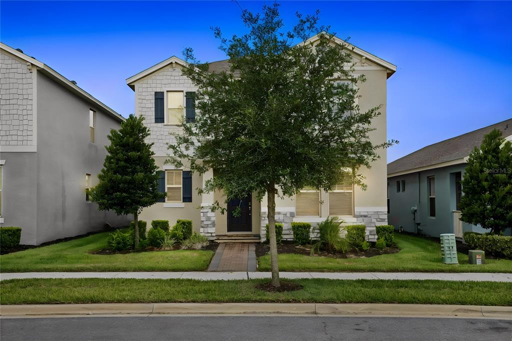 A two-story house with a beige exterior, stone accents, and a front walkway — 16161 MANGROVE ROAD, WINTER GARDEN, FL