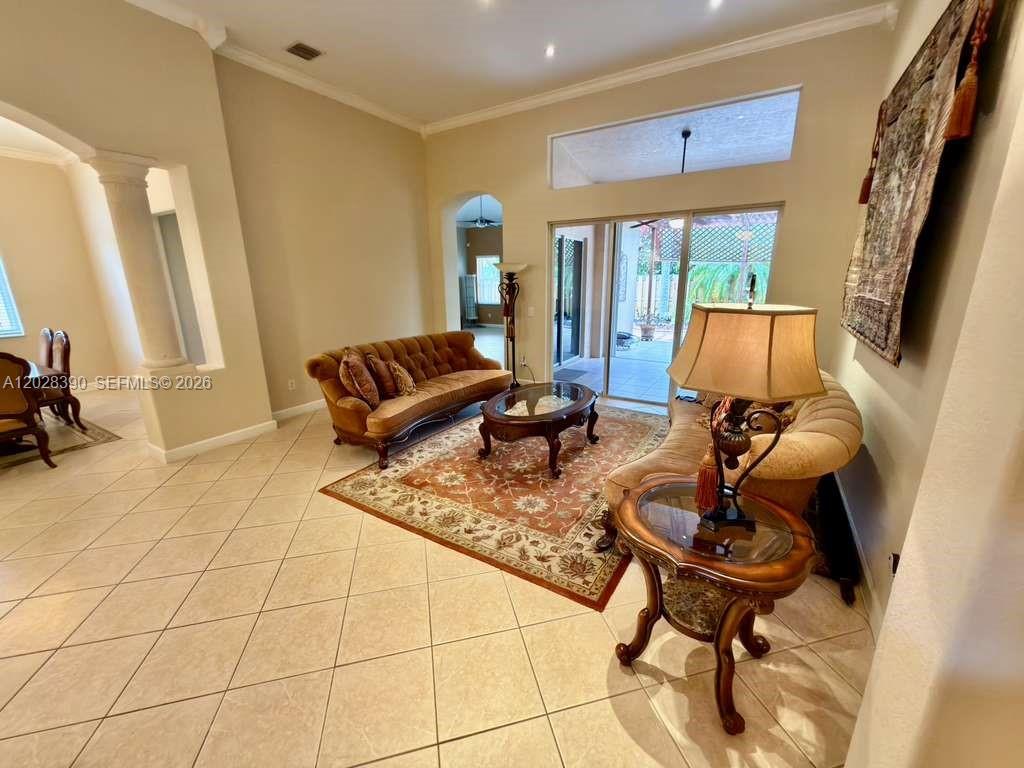 A living room features tile floors, a brown sofa, a patterned rug, and sliding glass doors — 3626 SW 161st Ter, Miramar FL 33027, MIRAMAR, FL