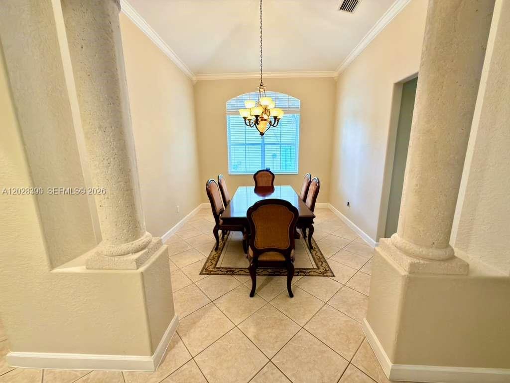 A dining room features a table with six chairs, a chandelier, and tiled flooring — 3626 SW 161st Ter, Miramar FL 33027, MIRAMAR, FL