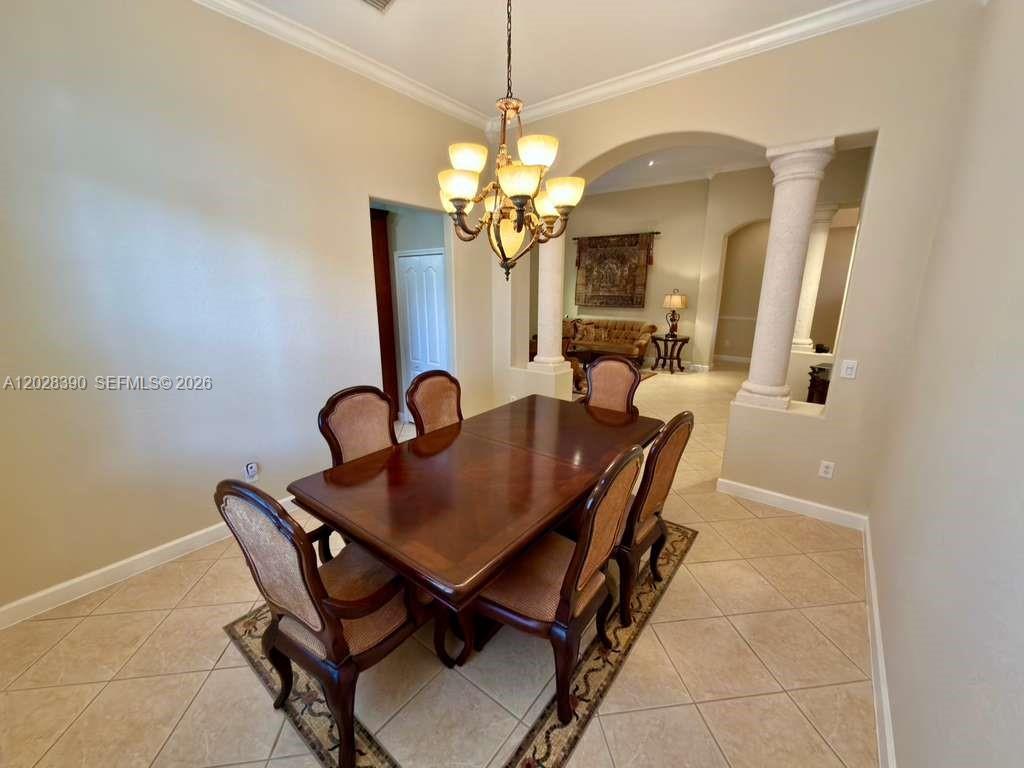 A dining room features a wooden table, six chairs, and a chandelier under an archway — 3626 SW 161st Ter, Miramar FL 33027, MIRAMAR, FL