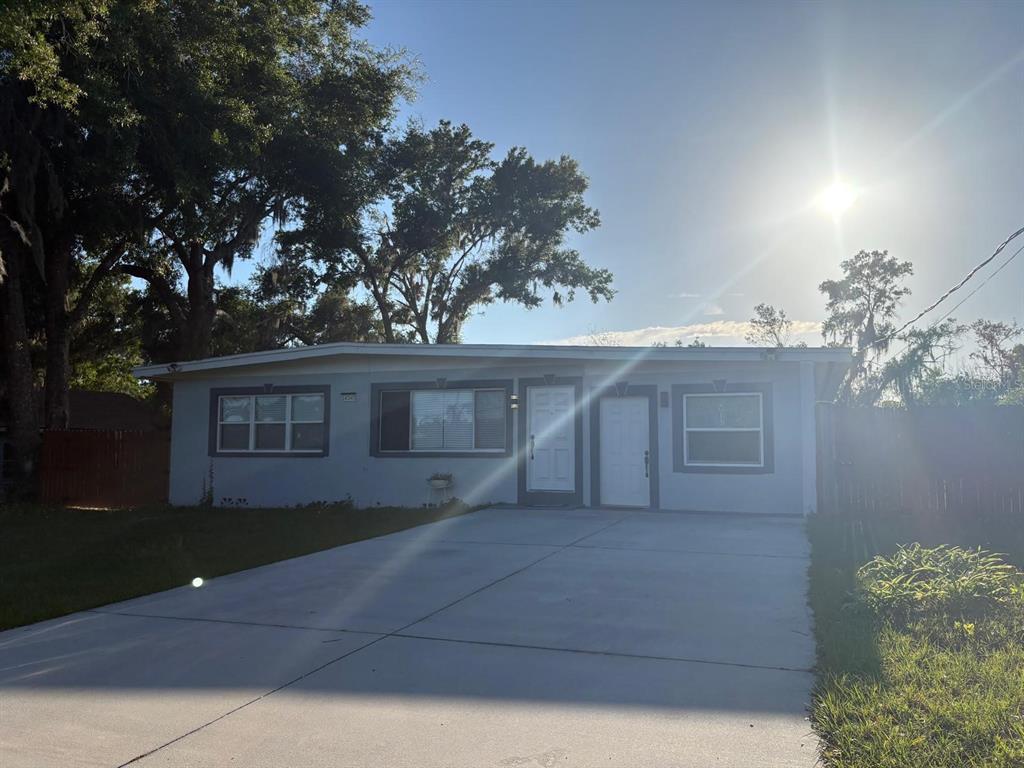 A single-story house with a concrete driveway, light gray siding, and two front doors — 14347 DELMAR STREET, DADE CITY, FL