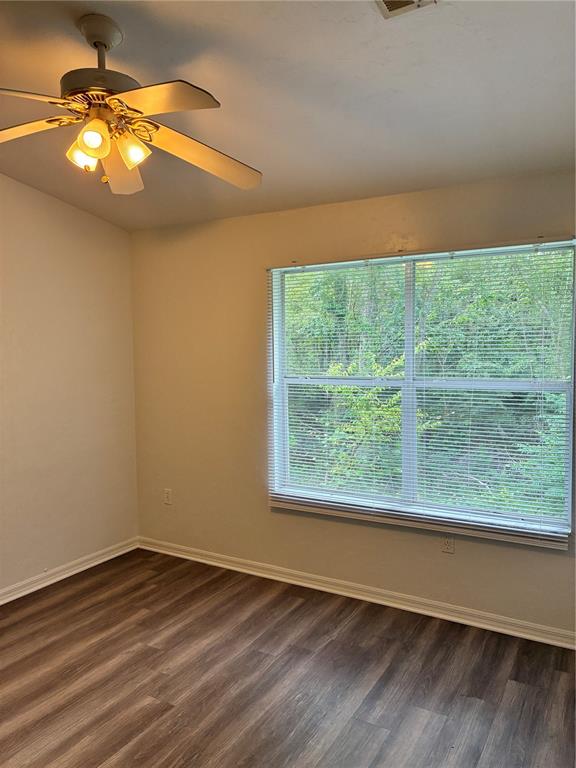 An empty bedroom features wood-look flooring, a ceiling fan, and a window with blinds — 4415 SW 34TH STREET UNIT 304, GAINESVILLE, FL