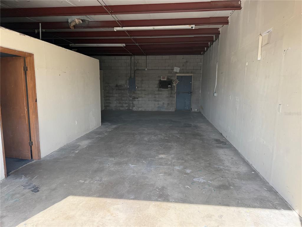 An empty commercial space features concrete floors, block walls, and exposed ceiling beams — 1706 N MAGNOLIA AVENUE UNIT 201, OCALA, FL