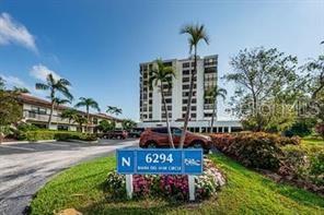 A multi-story apartment building stands behind a blue street sign and palm trees — 6294 BAHIA DEL MAR CIRCLE UNIT 103, ST PETERSBURG, FL