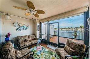 A sunroom features wicker furniture, a ceiling fan, and a large window overlooking the water — 6294 BAHIA DEL MAR CIRCLE UNIT 103, ST PETERSBURG, FL