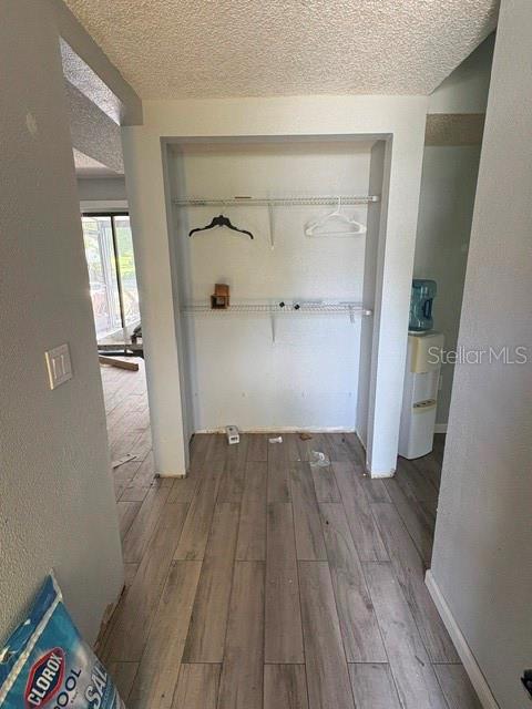A closet with wire shelving sits in a hallway with wood-look tile flooring — 7362 EDINBURGH WAY, WEEKI WACHEE, FL