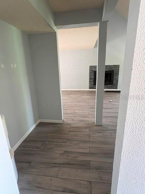 A view through a doorway into a living room with wood-look tile flooring and a fireplace — 7362 EDINBURGH WAY, WEEKI WACHEE, FL