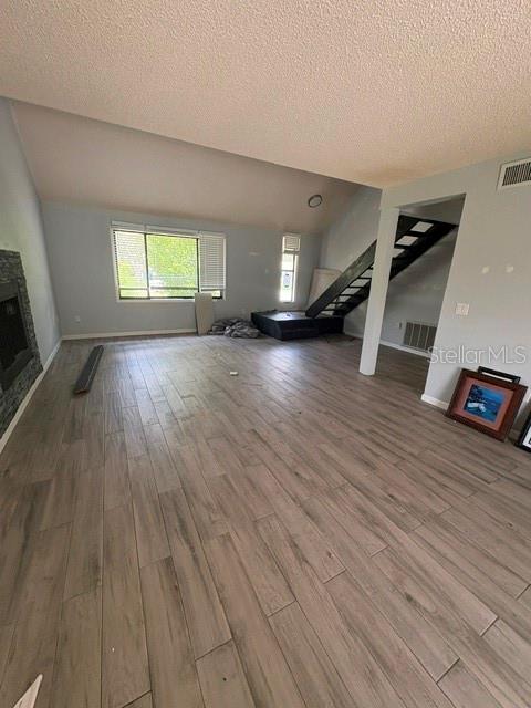 A living room features light wood-look tile flooring, a fireplace, and an open staircase — 7362 EDINBURGH WAY, WEEKI WACHEE, FL