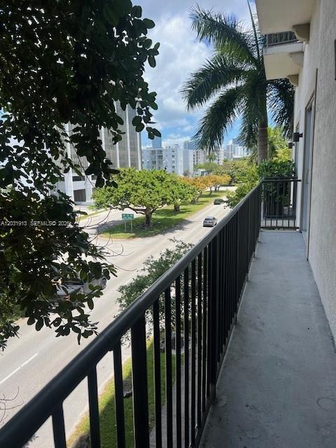 A view from a balcony overlooking a street with trees, buildings, and parked cars — 2701 SW 3rd Ave # 302, Miami FL 33129, MIAMI, FL