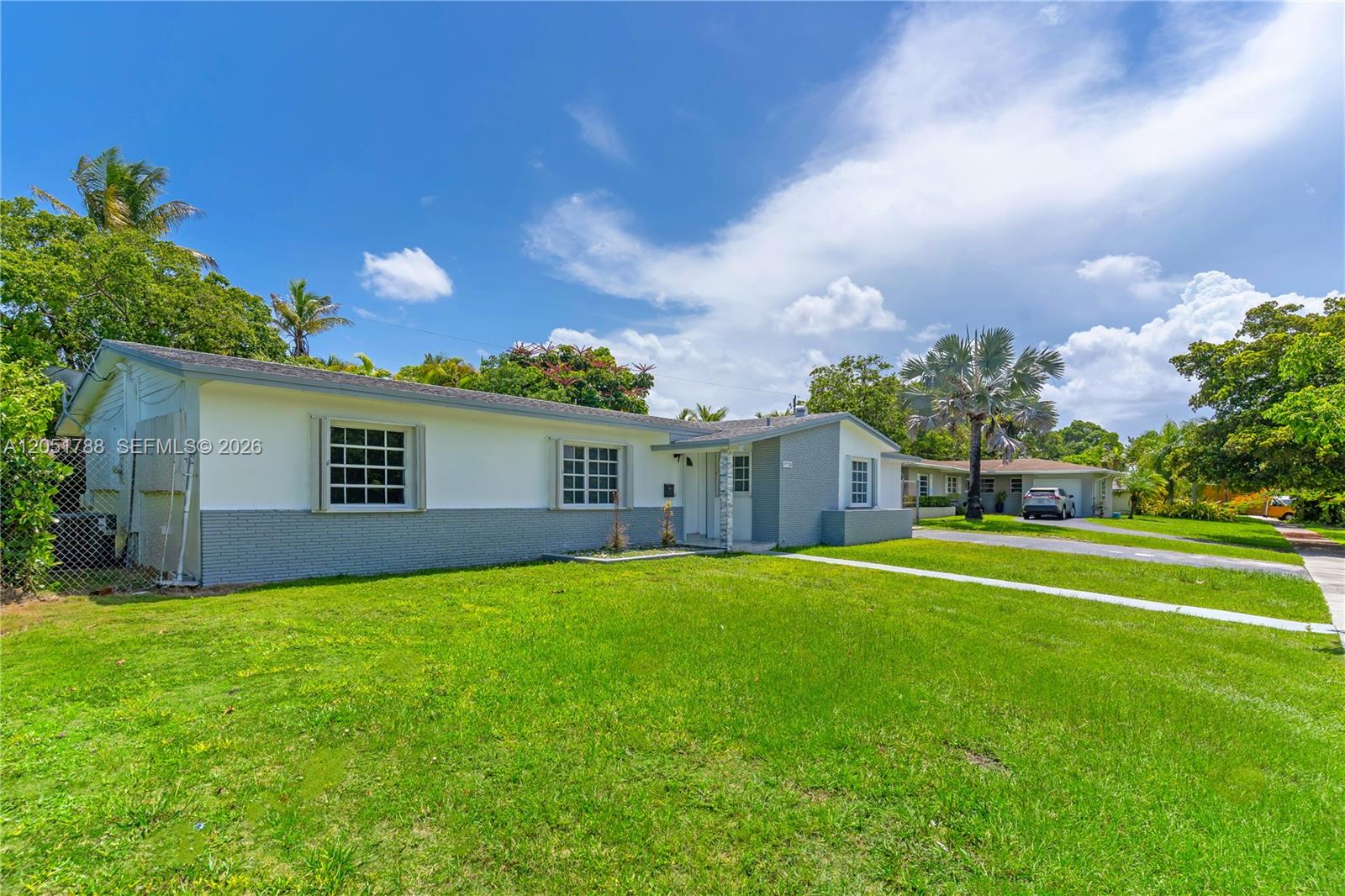 A single-story house with a white and gray exterior sits on a grassy lot — 9710 SW 159th St, Miami FL 33157, MIAMI, FL