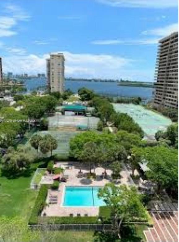 An aerial view shows a swimming pool, tennis courts, and a high-rise building by water — 11111 Biscayne Blvd # 4D, Miami FL 33181, MIAMI, FL