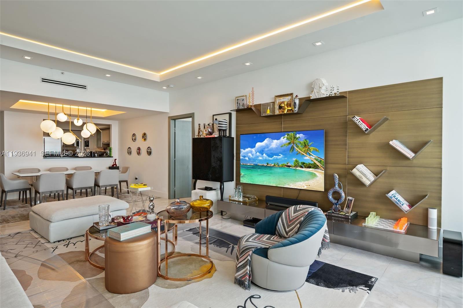 A modern living room features a large television, wood-paneled wall, and an adjacent dining area — 1331 Brickell Bay Dr # 2907, Miami FL 33131, MIAMI, FL