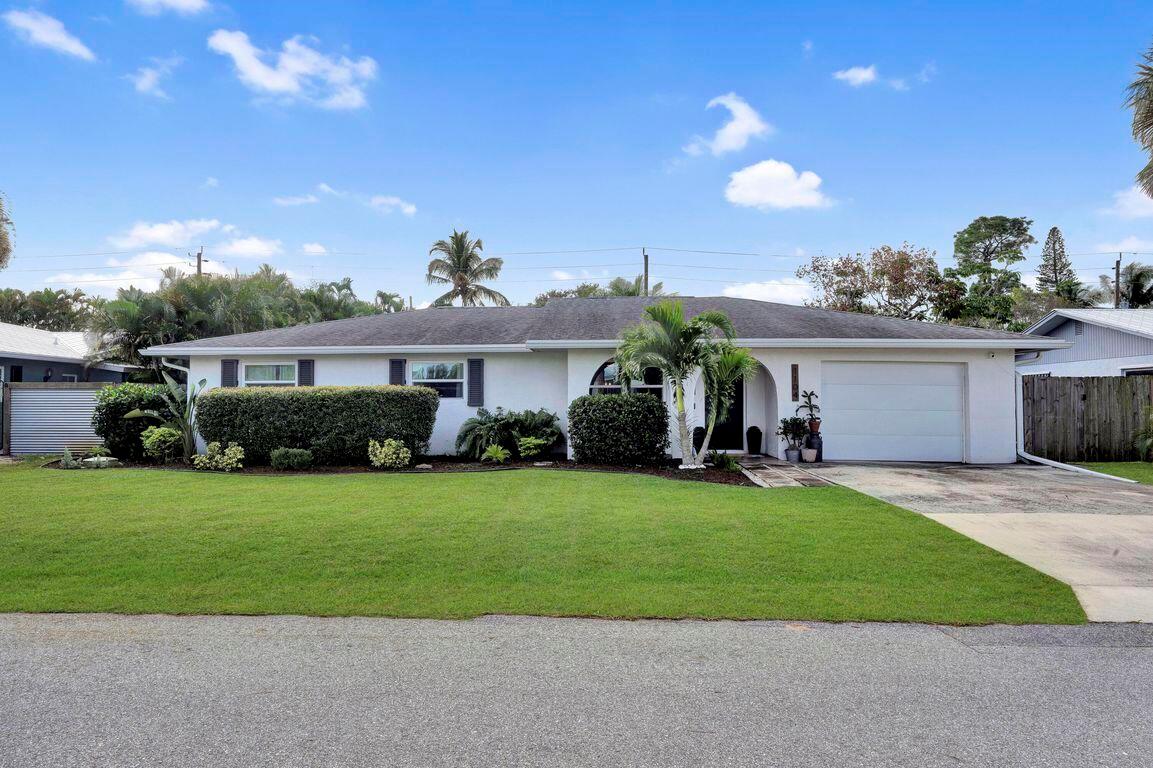 A single-story house with a white exterior, a green lawn, and an attached garage — 1104 NW 12th Terrace, Stuart FL 34994, STUART, FL