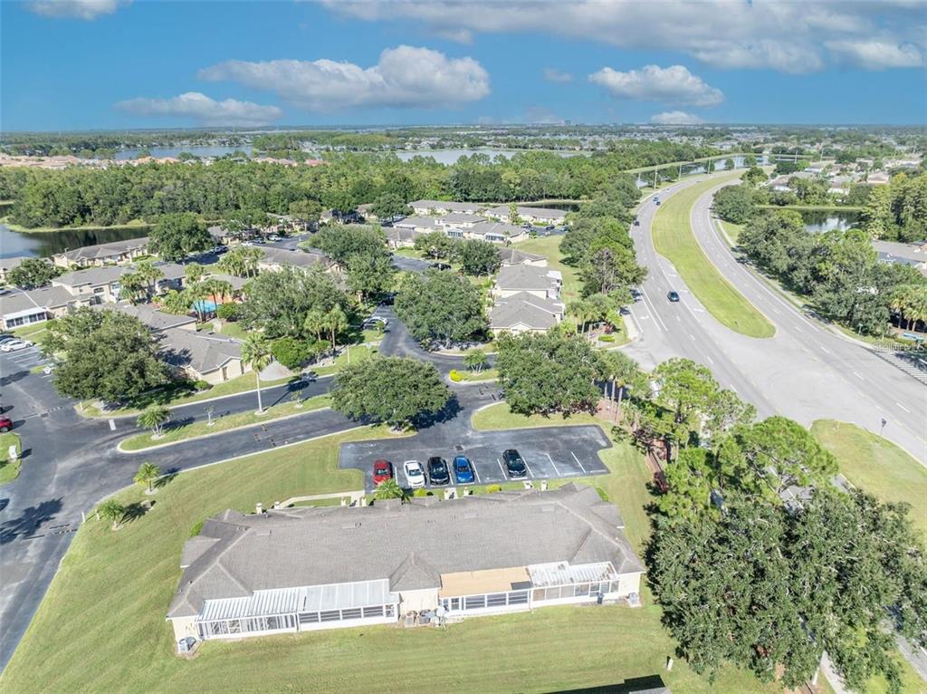 An aerial view shows a residential building with a screened patio next to a road — 3125 SANDY SHORE LANE, KISSIMMEE, FL