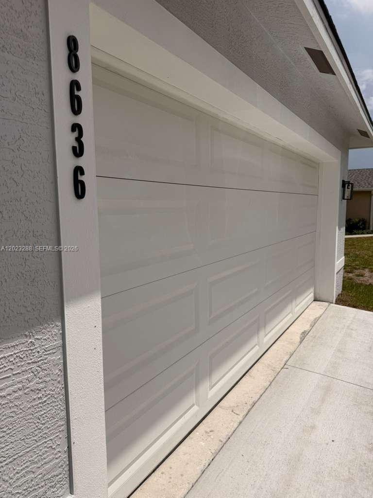 A white garage door with black vertical house numbers on the adjacent wall — 8636 100th Ct, Vero Beach FL 32967, VERO BEACH, FL