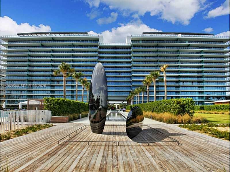 A modern residential building exterior features two large, reflective, oval-shaped sculptures on a wooden deck — 350 Ocean Dr # 406N, Key Biscayne FL 33149, KEY BISCAYNE, FL