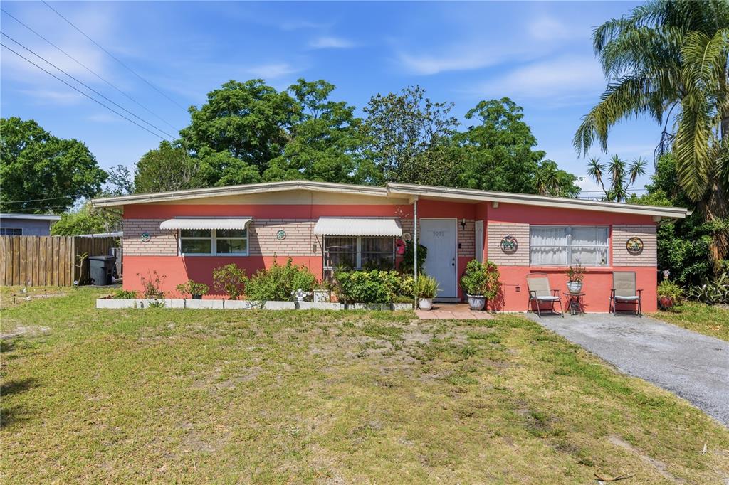 A single-story house with a coral-colored exterior, white trim, and a front lawn — 5031 GRAND BOULEVARD, NEW PORT RICHEY, FL