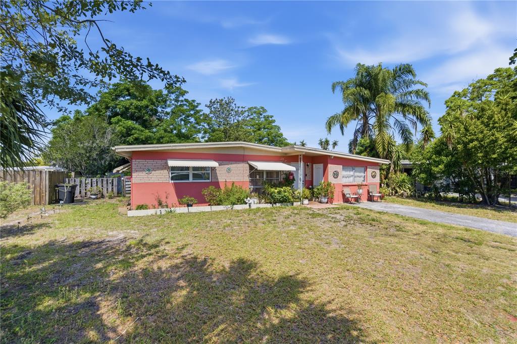A single-story house with a red exterior, brick accents, and a large front lawn — 5031 GRAND BOULEVARD, NEW PORT RICHEY, FL