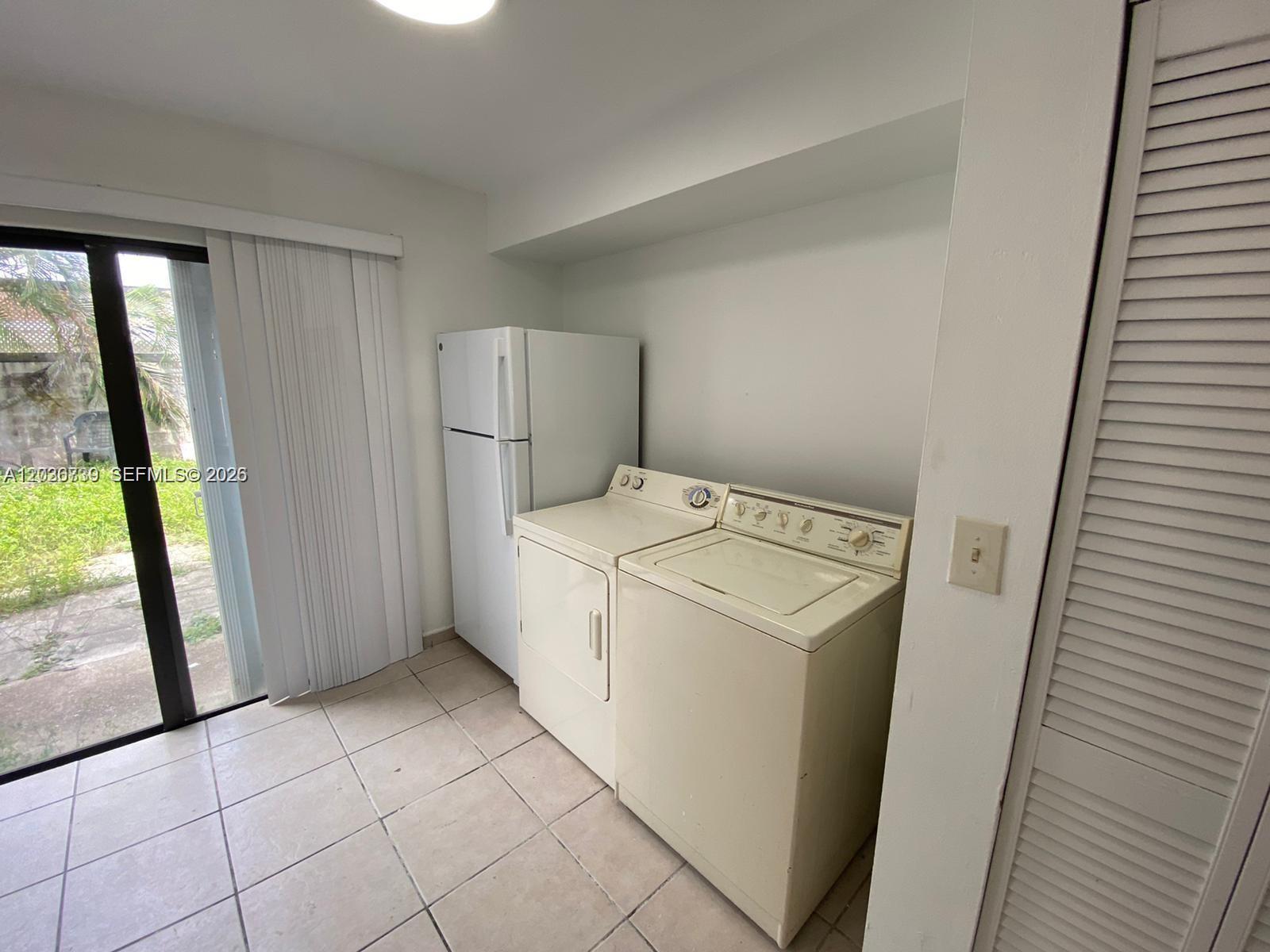 A laundry area features a refrigerator, a washer, and a dryer on a tiled floor — 1813 SW 107th Ave # 2402, Miami FL 33165, MIAMI, FL