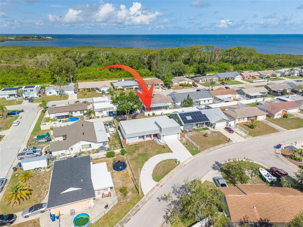 An aerial view shows a residential neighborhood with a house highlighted by a red arrow — 3543 ROCKAWAY DRIVE, HOLIDAY, FL