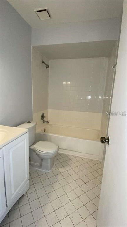 A bathroom features a white vanity, a toilet, and a shower-tub combination with white tiles — 5214 VIA HACIENDA CIRCLE UNIT A306, ORLANDO, FL