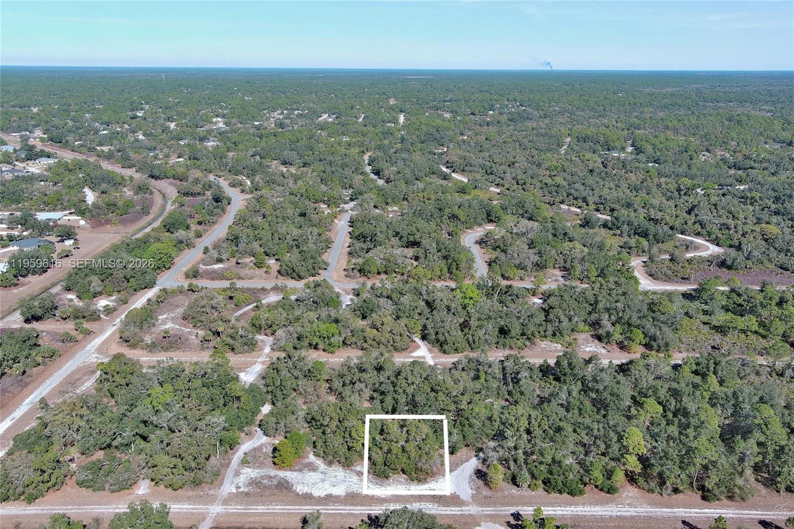 An aerial view shows a wooded, undeveloped residential lot outlined in white within a subdivision — 0 Ames Ave, North Port FL 34291, NORTH PORT, FL