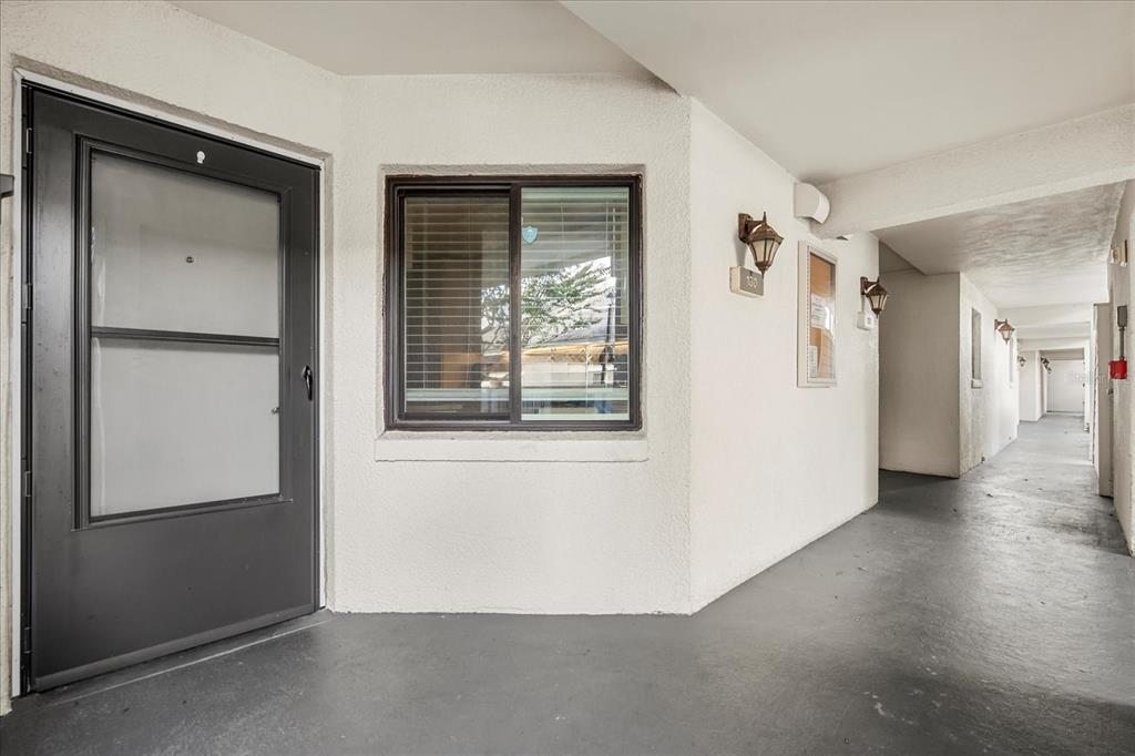 An exterior view of a building entrance with a dark door, window, and covered walkway — 4101 FAIRVIEW VISTA POINT UNIT 130, ORLANDO, FL