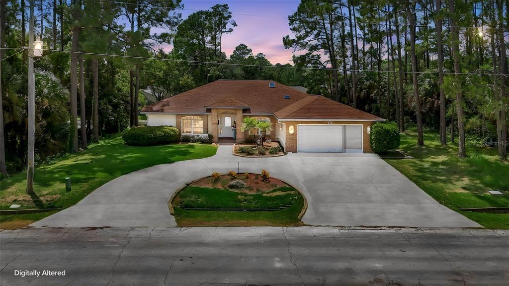A single-story house with a brown roof, brick accents, and a circular driveway in a forest — 73 WATERS DRIVE, PALM COAST, FL