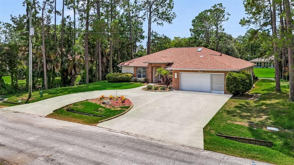 A single-story brick house with a two-car garage and a circular concrete driveway — 73 WATERS DRIVE, PALM COAST, FL