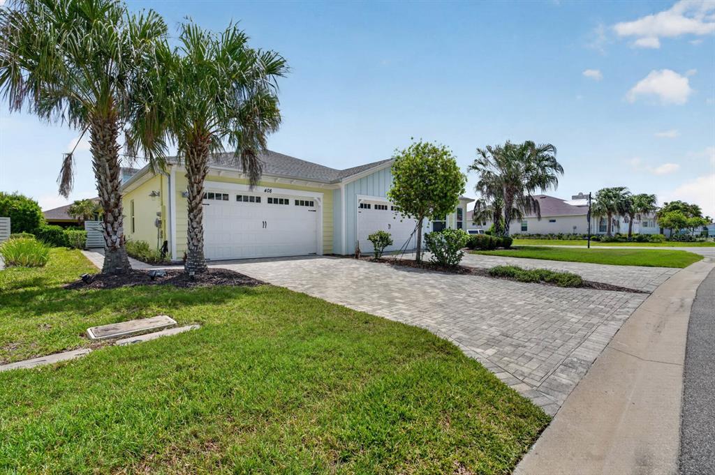 A single-story house with a paved driveway, two garage doors, and palm trees in front — 408 LOST SHAKER WAY, DAYTONA BEACH, FL