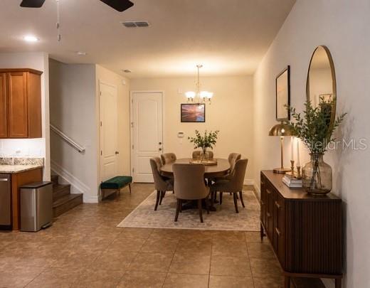 A dining area with a wooden table, chairs, and a sideboard sits near a kitchen — 9999 EAGLE CREEK CENTER BOULEVARD, ORLANDO, FL