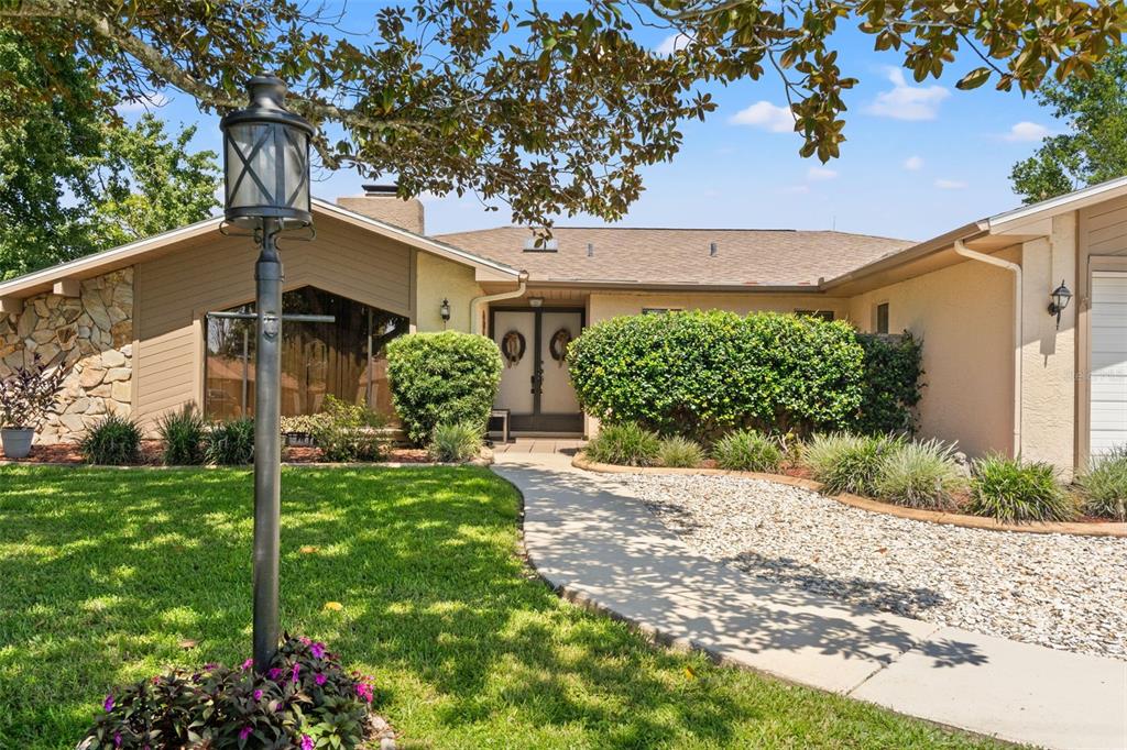 A single-story house with a stone facade, a lamp post, and a concrete walkway — 2278 ARDENWOOD DRIVE, SPRING HILL, FL