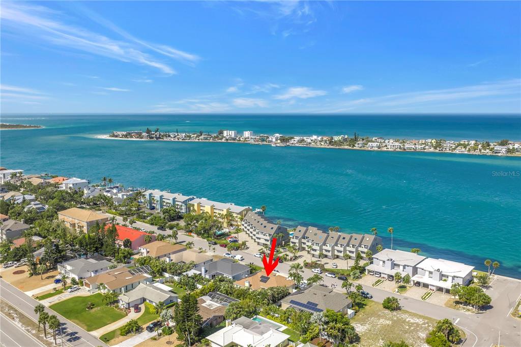 An aerial view shows a residential neighborhood with a red arrow pointing to a house — 343 8TH AVENUE N, TIERRA VERDE, FL