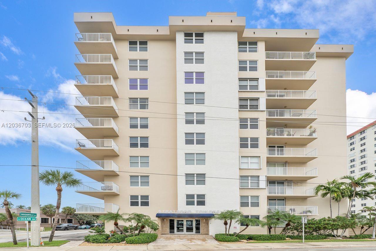 The exterior of a multi-story beige apartment building features stacked balconies and a ground-level entrance — 1401 S Ocean Dr # 305, Hollywood FL 33019, HOLLYWOOD, FL
