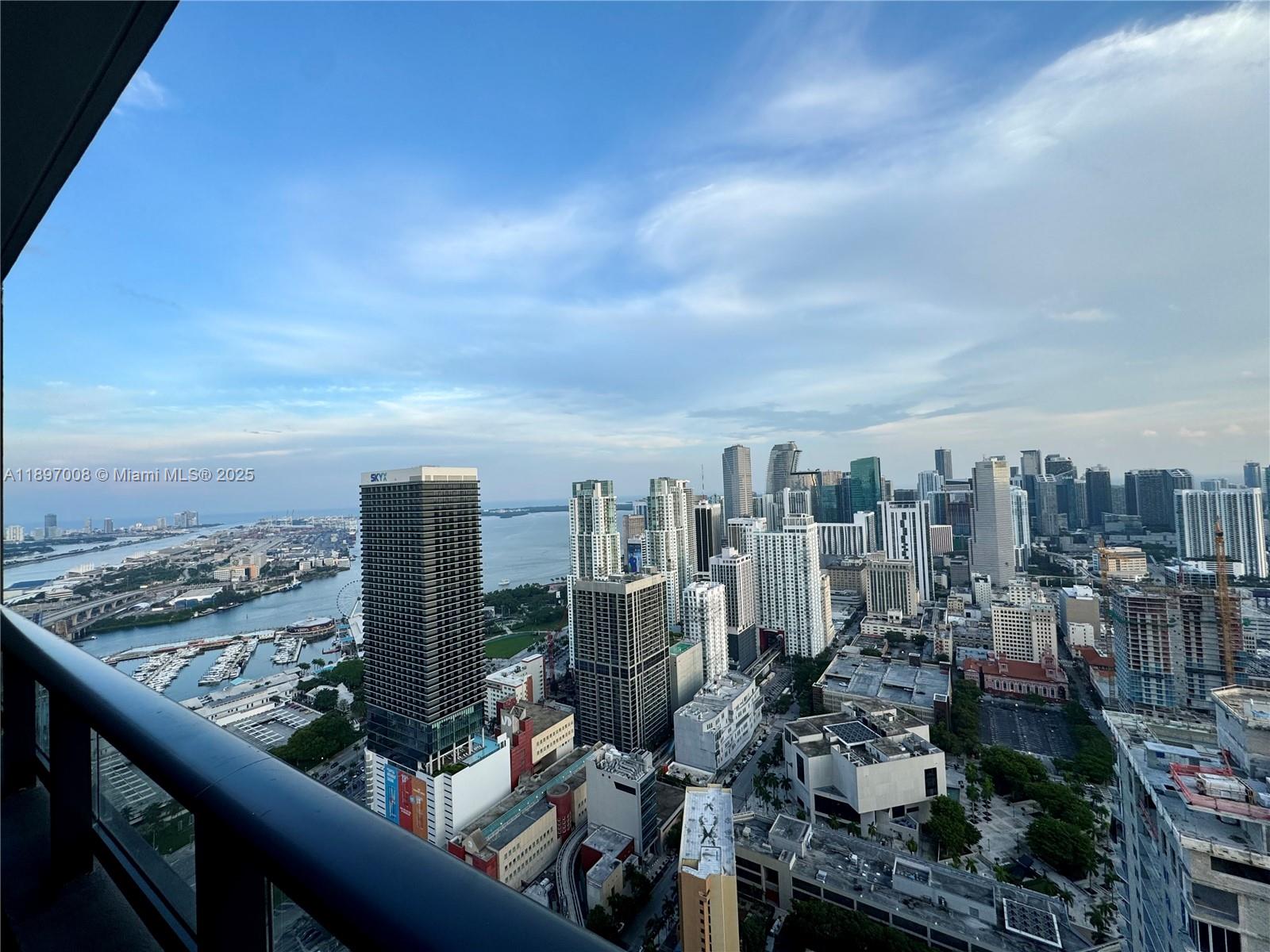 A high-angle view of the Miami skyline and harbor from a balcony — 159 NE 6th St # 4807, Miami FL 33132, MIAMI, FL