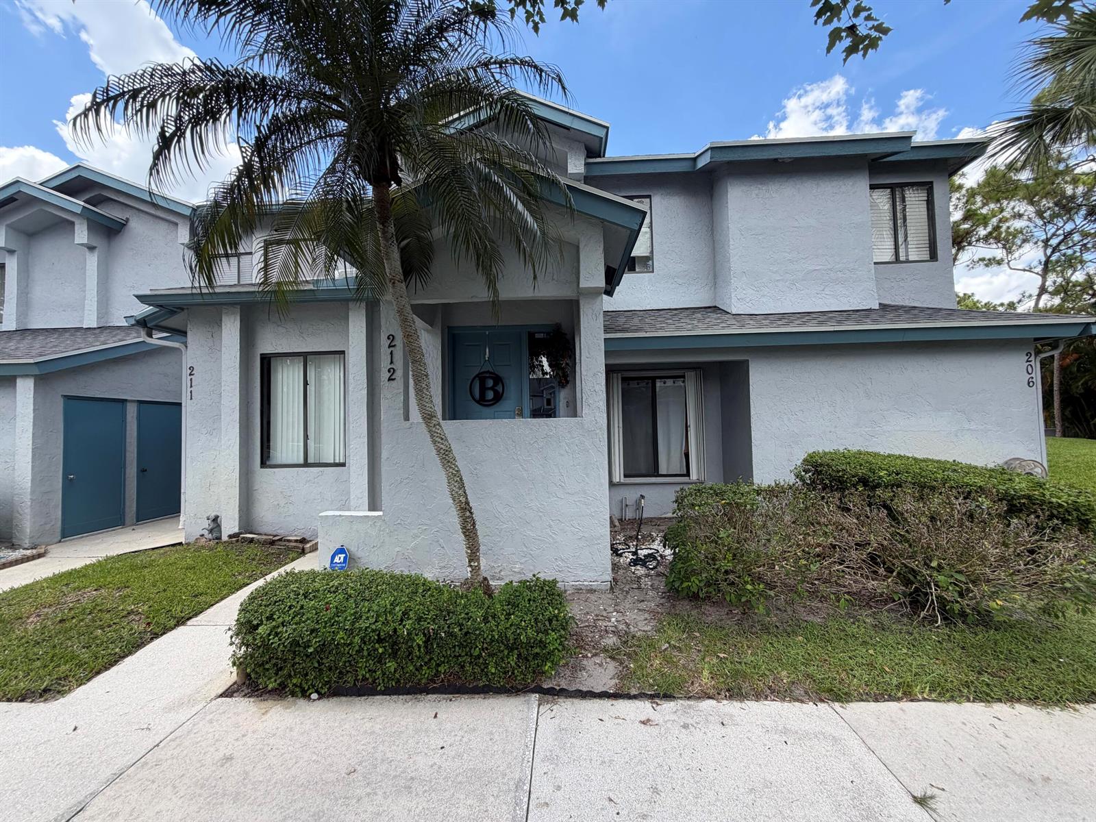 A two-story gray stucco townhouse with a blue front door and a palm tree — 212 Harbour Pointe Way, FL 33413, FL