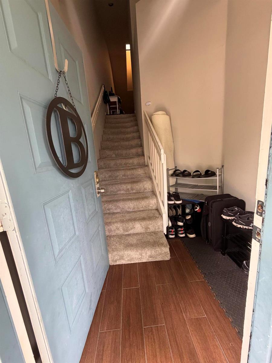 An entryway features a light blue door, wood-look tile flooring, and carpeted stairs leading upward — 212 Harbour Pointe Way, FL 33413, FL