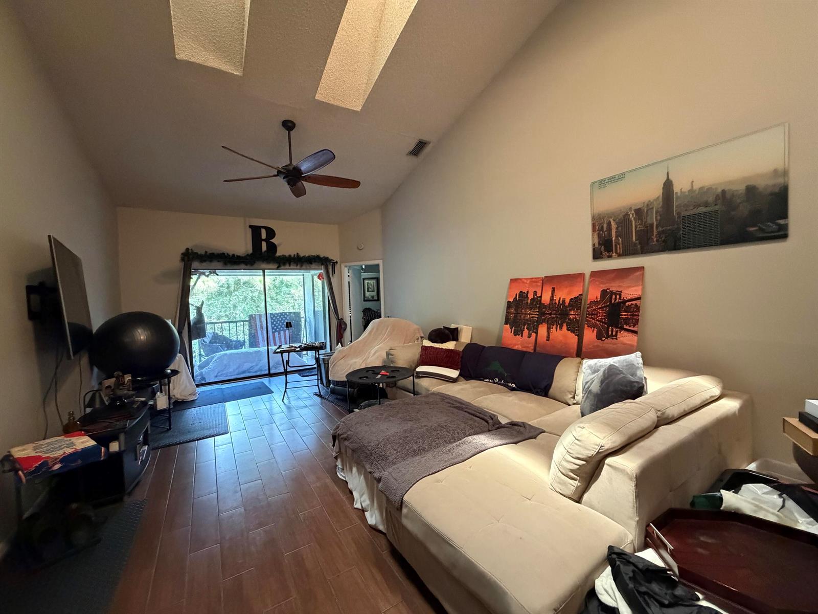 A living room with a sectional sofa, vaulted ceilings, and a sliding glass door — 212 Harbour Pointe Way, FL 33413, FL