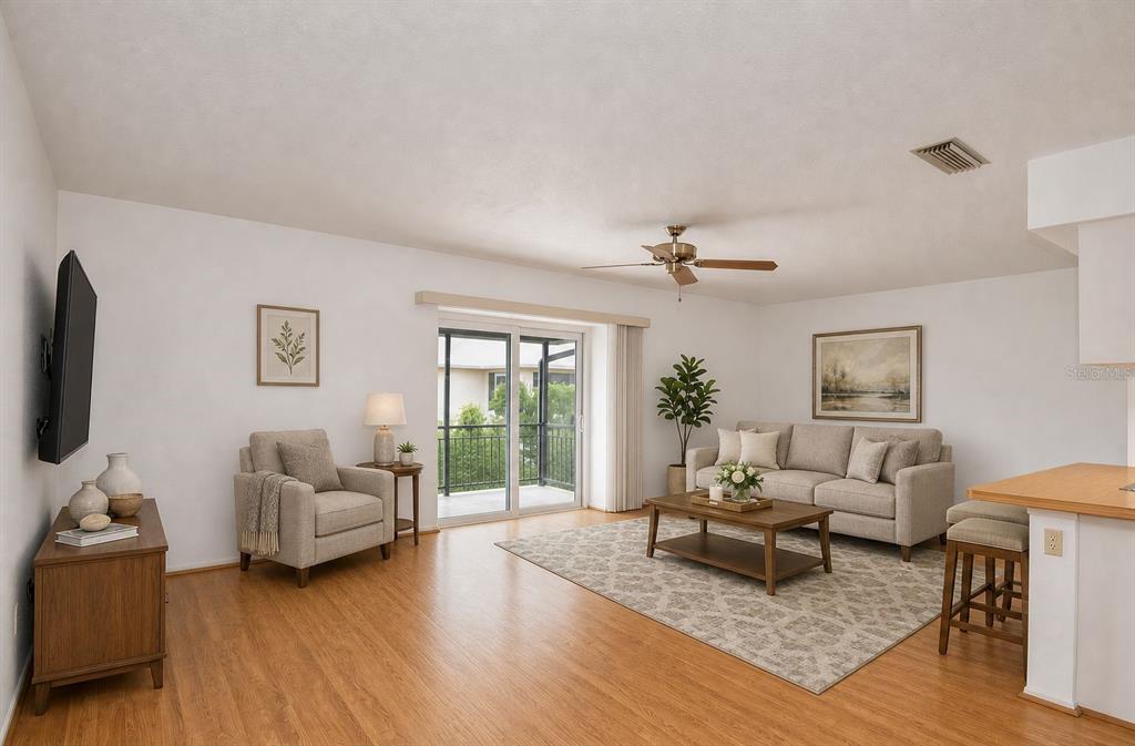 A living room features light wood floors, a beige sofa, an armchair, and a balcony — 1379 EVEREST ROAD, VENICE, FL