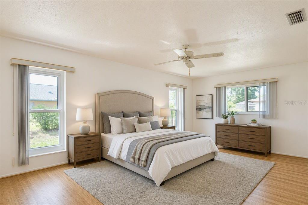 A bedroom features a light-colored bed, two wooden nightstands, a dresser, and light wood flooring — 1379 EVEREST ROAD, VENICE, FL