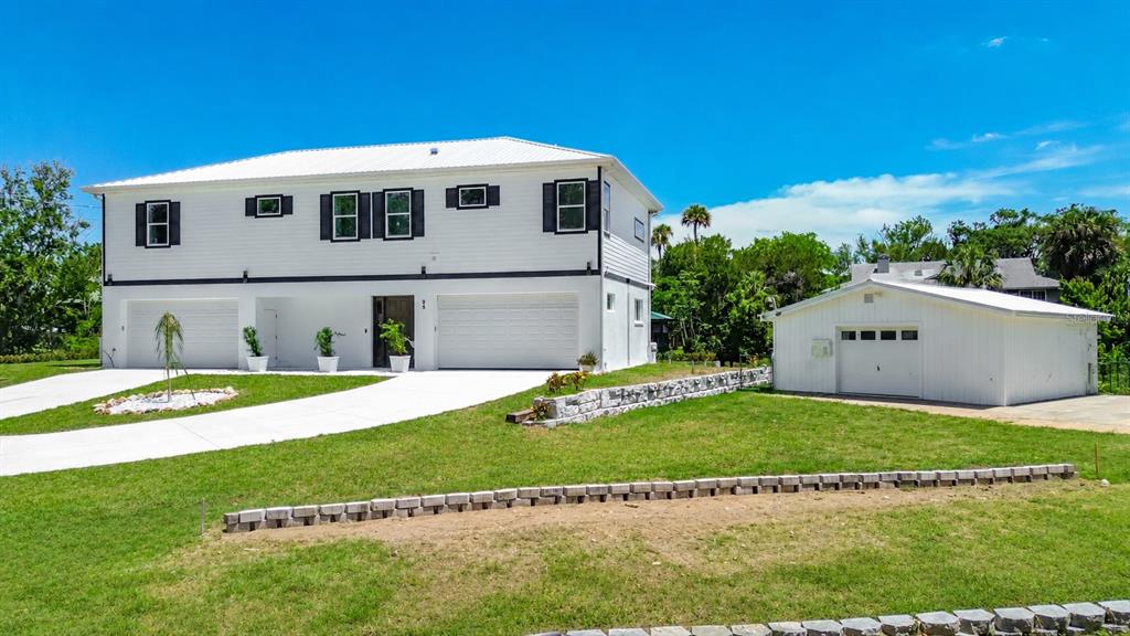 A two-story white house with a detached garage sits on a grassy lot — 25 PALM DRIVE, YANKEETOWN, FL