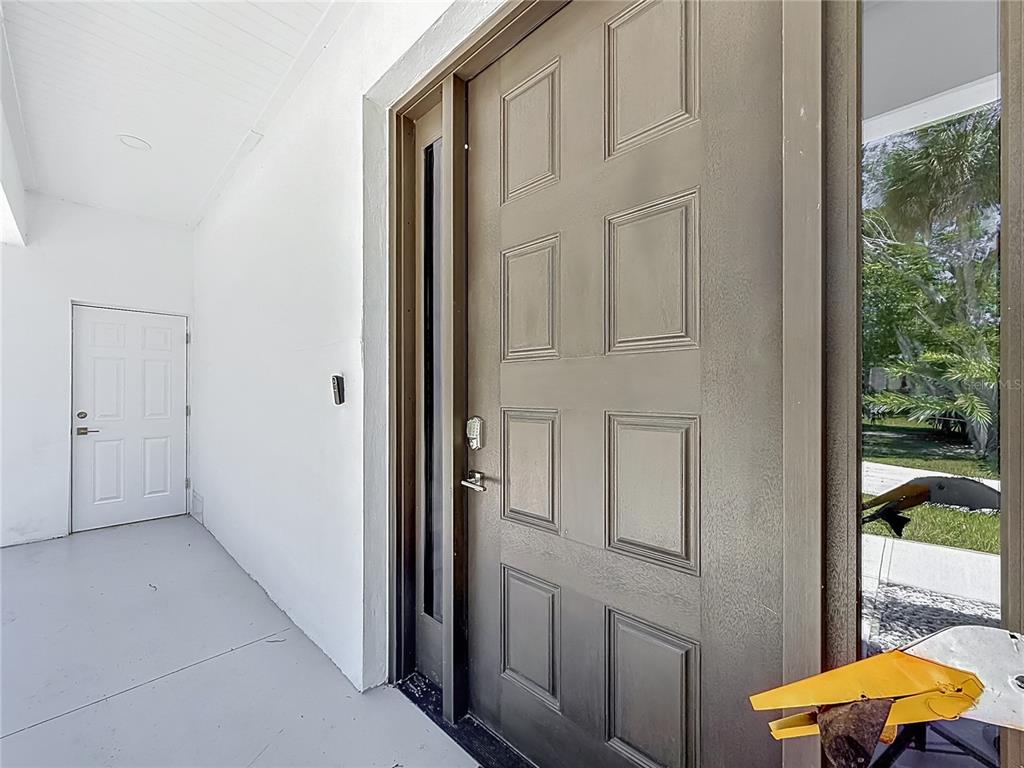 A brown front door with a keypad lock sits next to a white side door — 25 PALM DRIVE, YANKEETOWN, FL