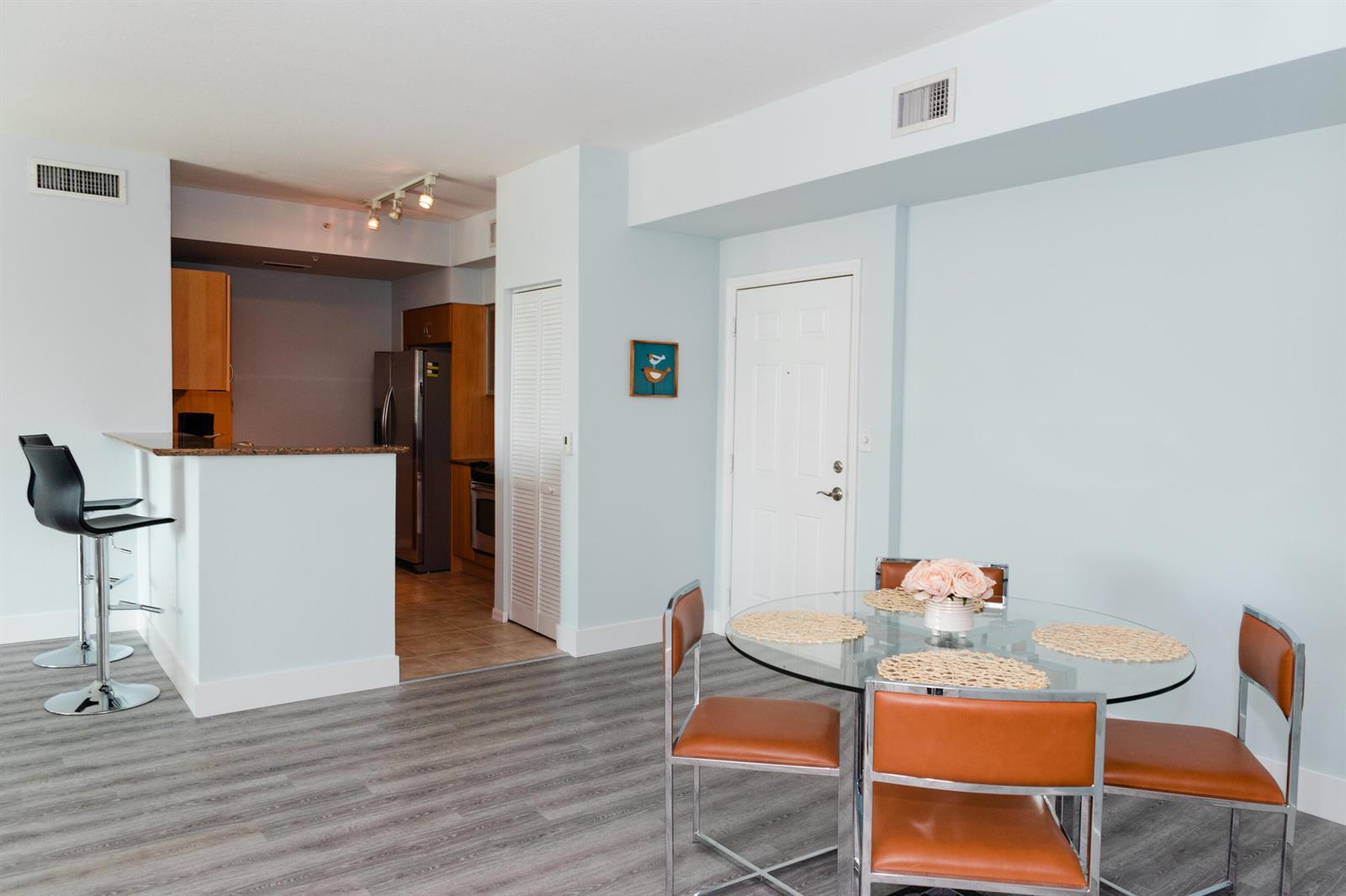 A dining area with a glass table and chairs sits adjacent to an open kitchen — 802 W Windward Way # 311, Lantana FL 33462, LANTANA, FL