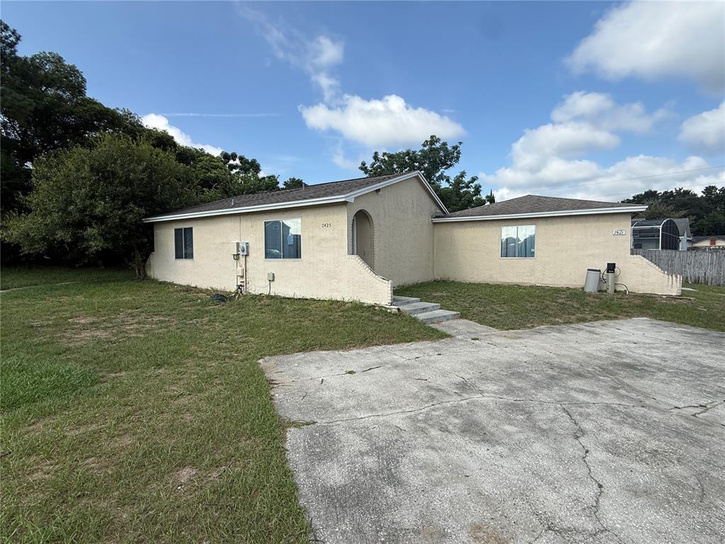A single-story stucco house with a concrete driveway and a small front yard — 7425 VILLAS OAK COURT, ORLANDO, FL