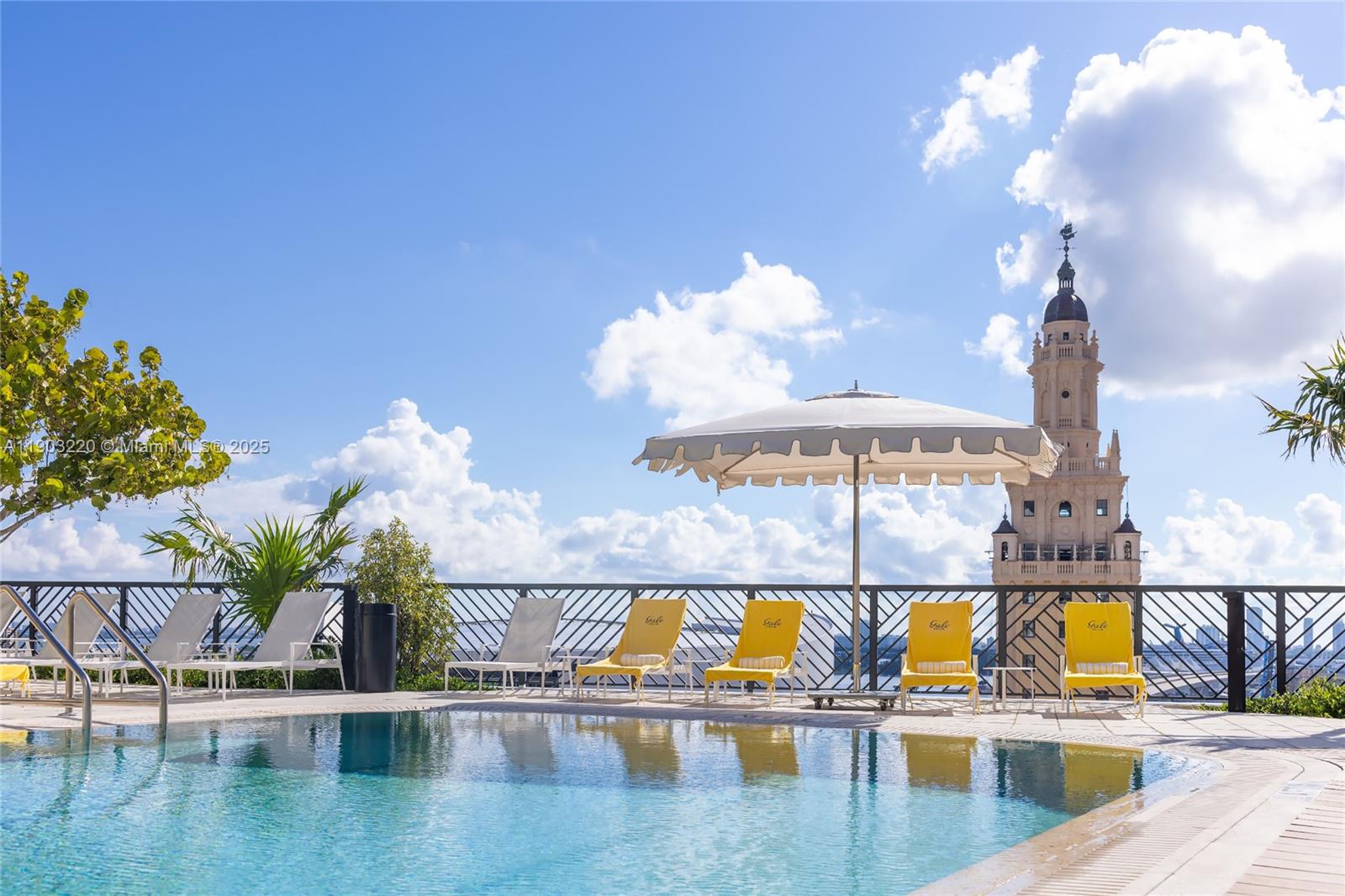 A swimming pool with lounge chairs and an umbrella overlooks the Freedom Tower in Miami — 159 NE 6th St # 3615, Miami FL 33132, MIAMI, FL