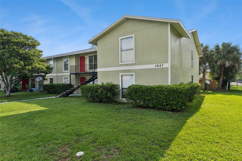 A two-story apartment building with light green siding and an exterior metal staircase — 1847 CARALEE BOULEVARD UNIT 4, ORLANDO, FL