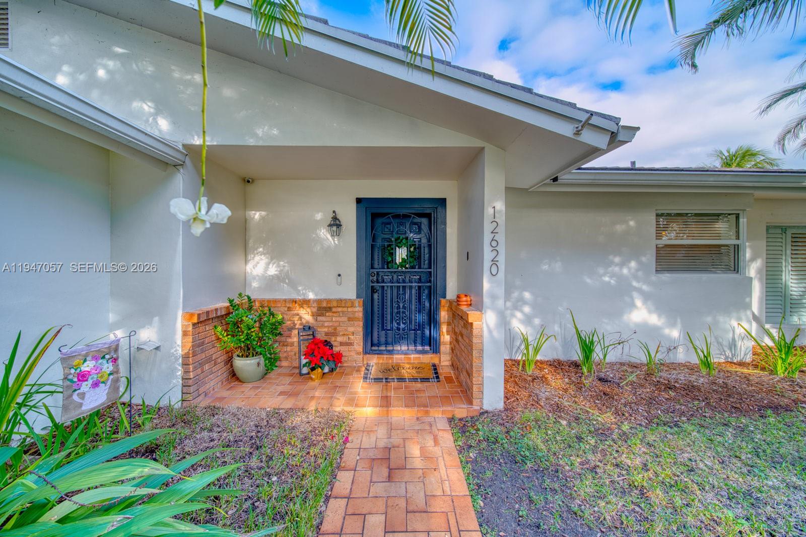 The front entrance features a brick walkway, a dark metal door, and a brick porch — 12620 SW 114th Ave, Miami FL 33176, MIAMI, FL