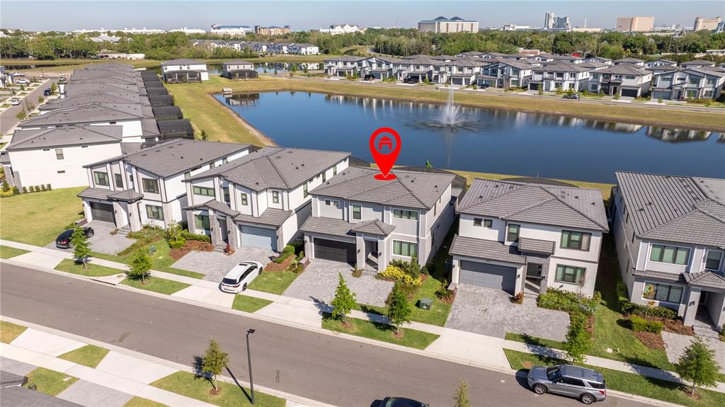 An aerial view shows a two-story house with a red location pin by a pond — 5860 HIGH SEAS DRIVE, ORLANDO, FL