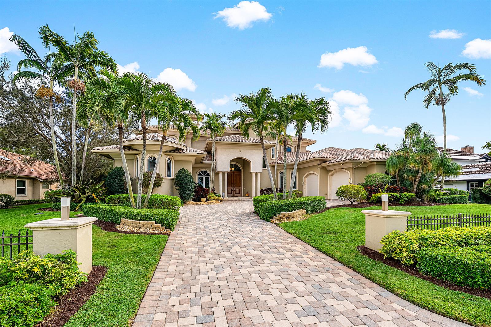 A paved driveway leads to the entrance of a two-story house with palm trees — 4304 Saint Andrews Drive, Boynton Beach FL 33436, BOYNTON BEACH, FL